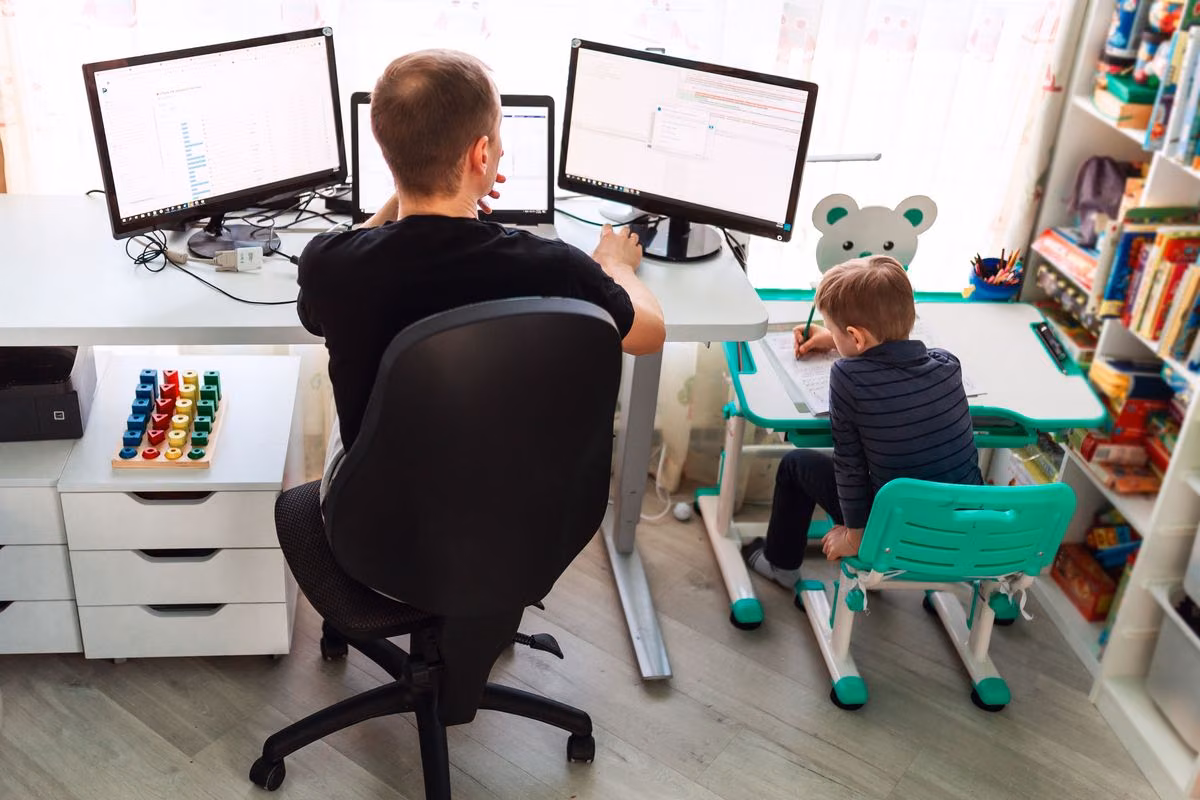 Arbeitender Vater mit Kind am Tisch Arbeitender Vater mit Kind am Tisch