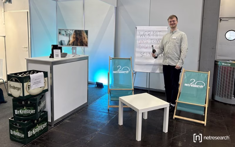 Messestand von Netresearch auf der INTEC 2025 mit Liegestühlen und Bierkästen